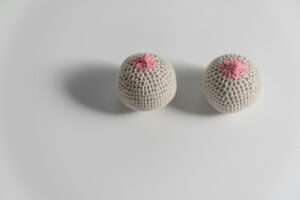 Two crocheted breast models symbolizing breast cancer awareness and feminism.