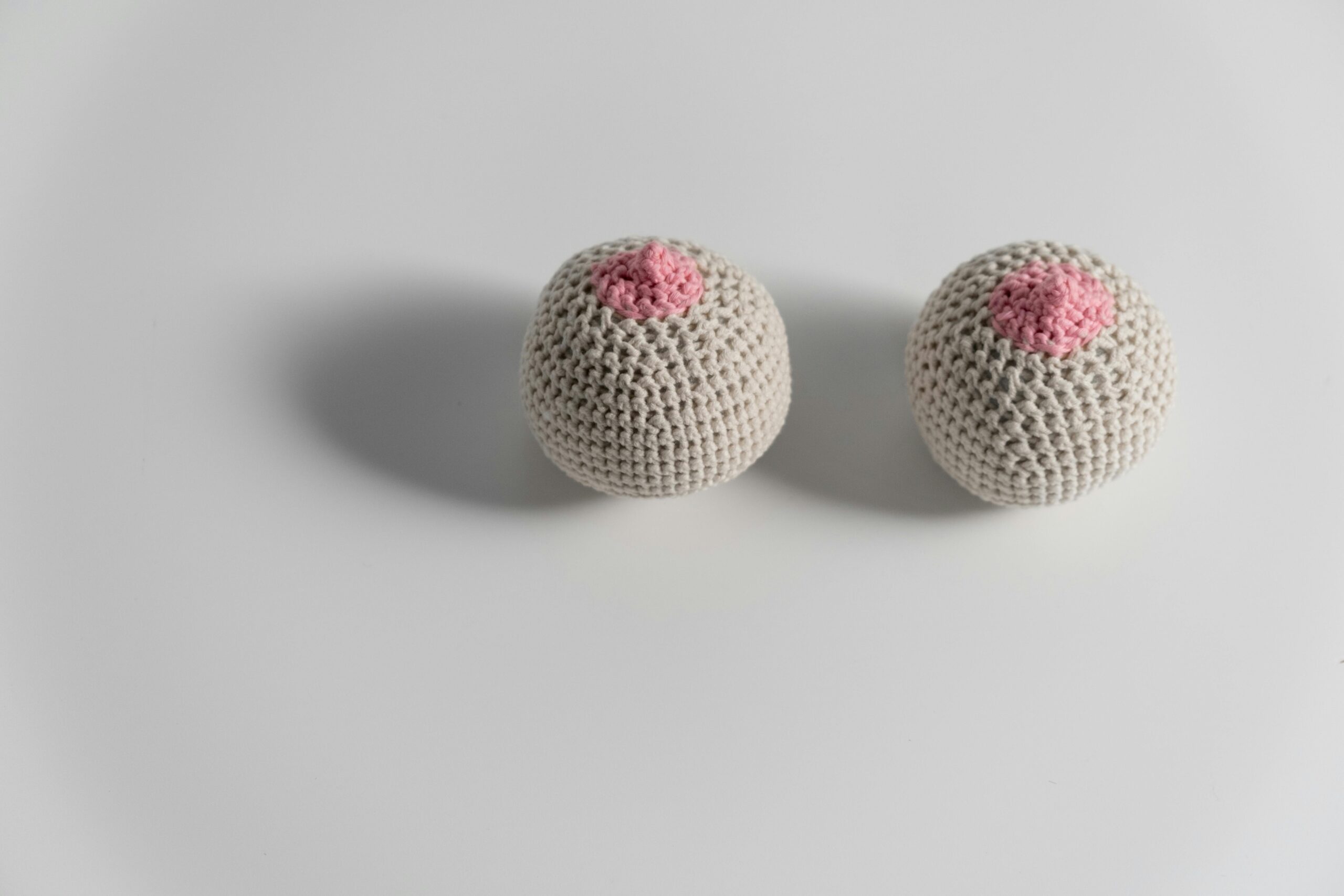 Two crocheted breast models symbolizing breast cancer awareness and feminism.